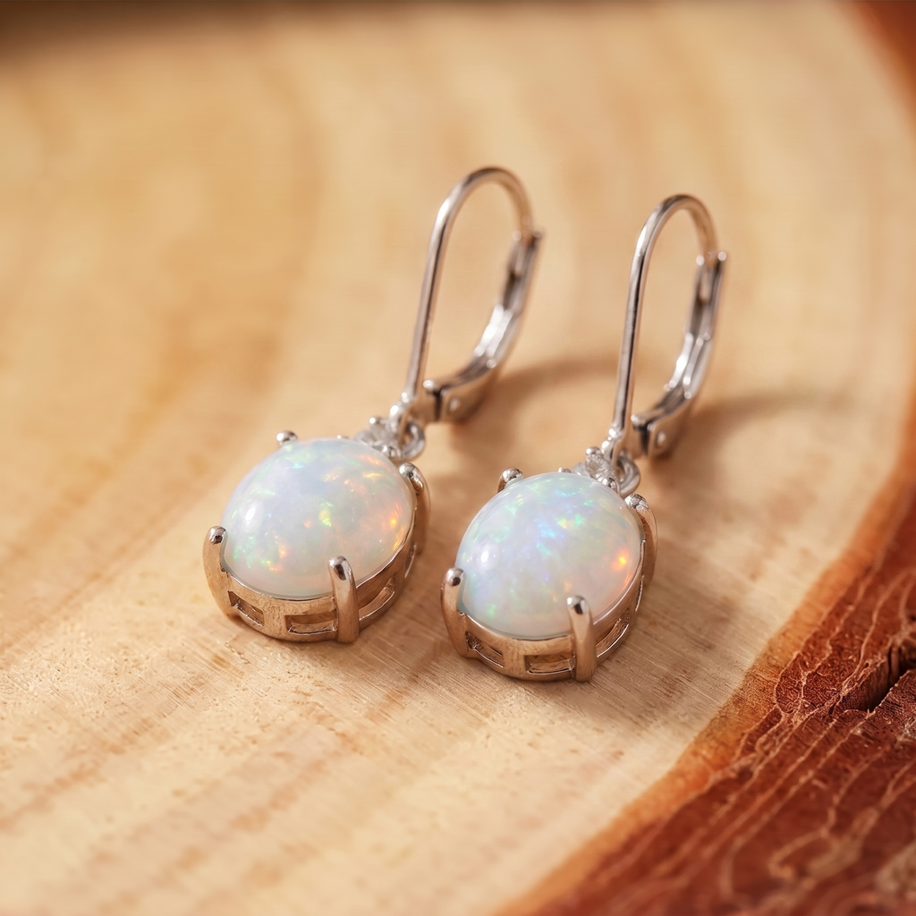 Silver Fire Opal Lever-Back Drops on a tree-trunk slab