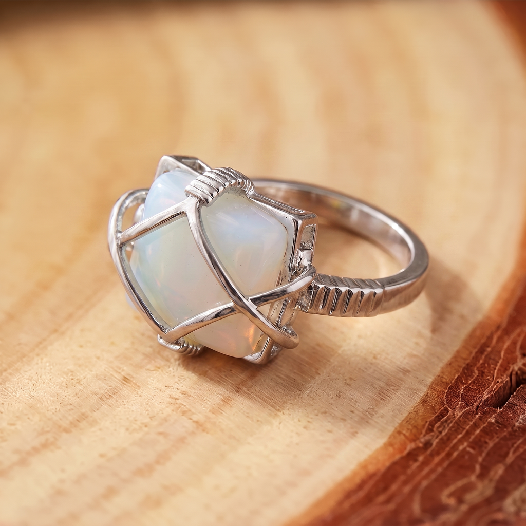 White Opal Wire-Wrapped Silver Ring on a tree-trunk slab