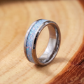 Blue Opal Inlay Steel Band Ring on a tree-trunk slab