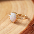 White Opal Dainty Gold Ring on a tree-trunk slab