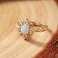 White Opal Baroque Gold Ring on a tree-trunk slab