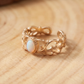 White Opal Leaf Gold Ring on a tree-trunk slab