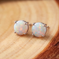 White Opal Silver Stud Earrings on a tree-trunk slab