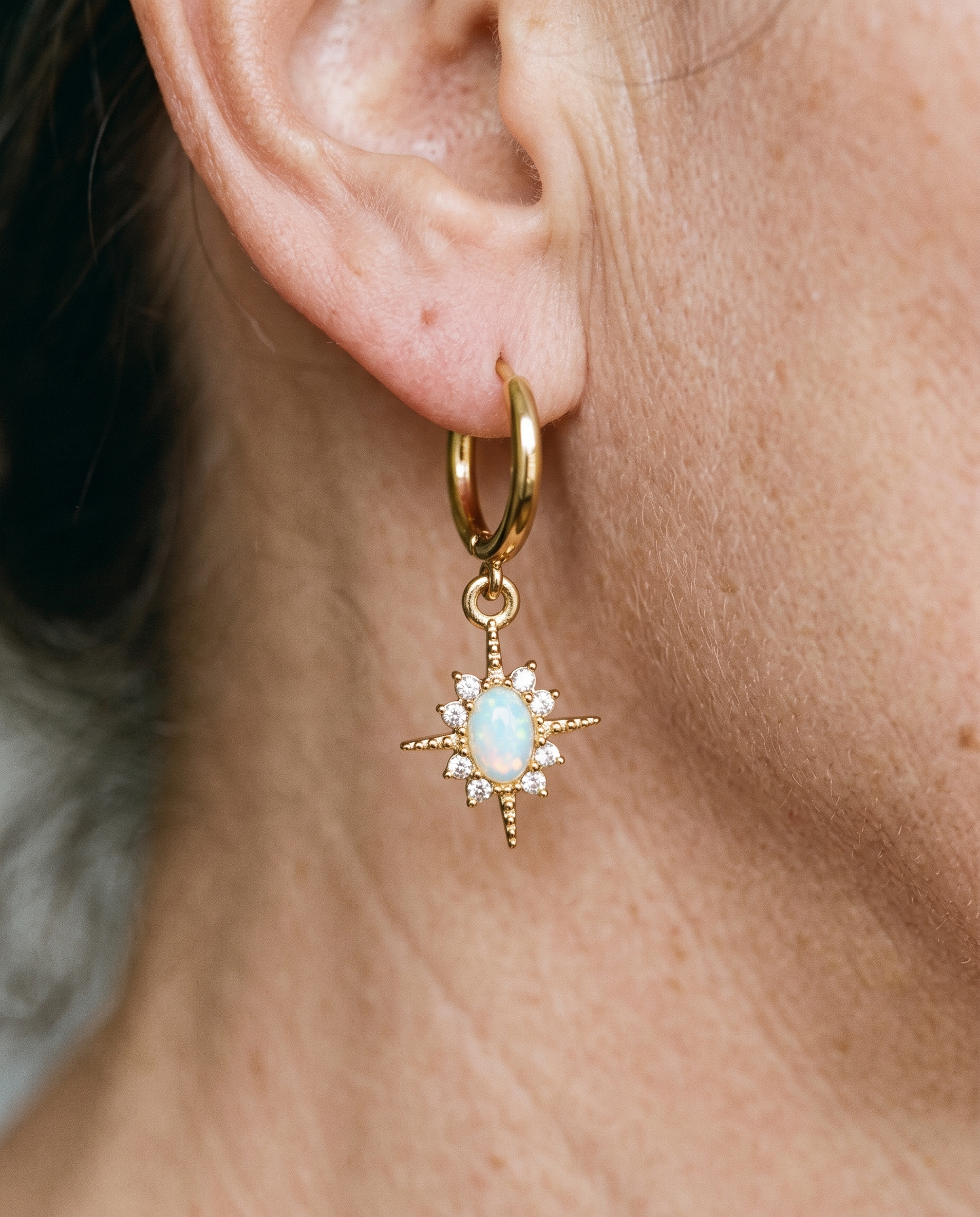 Celestial Opal Star Huggie Hoops worn on a model