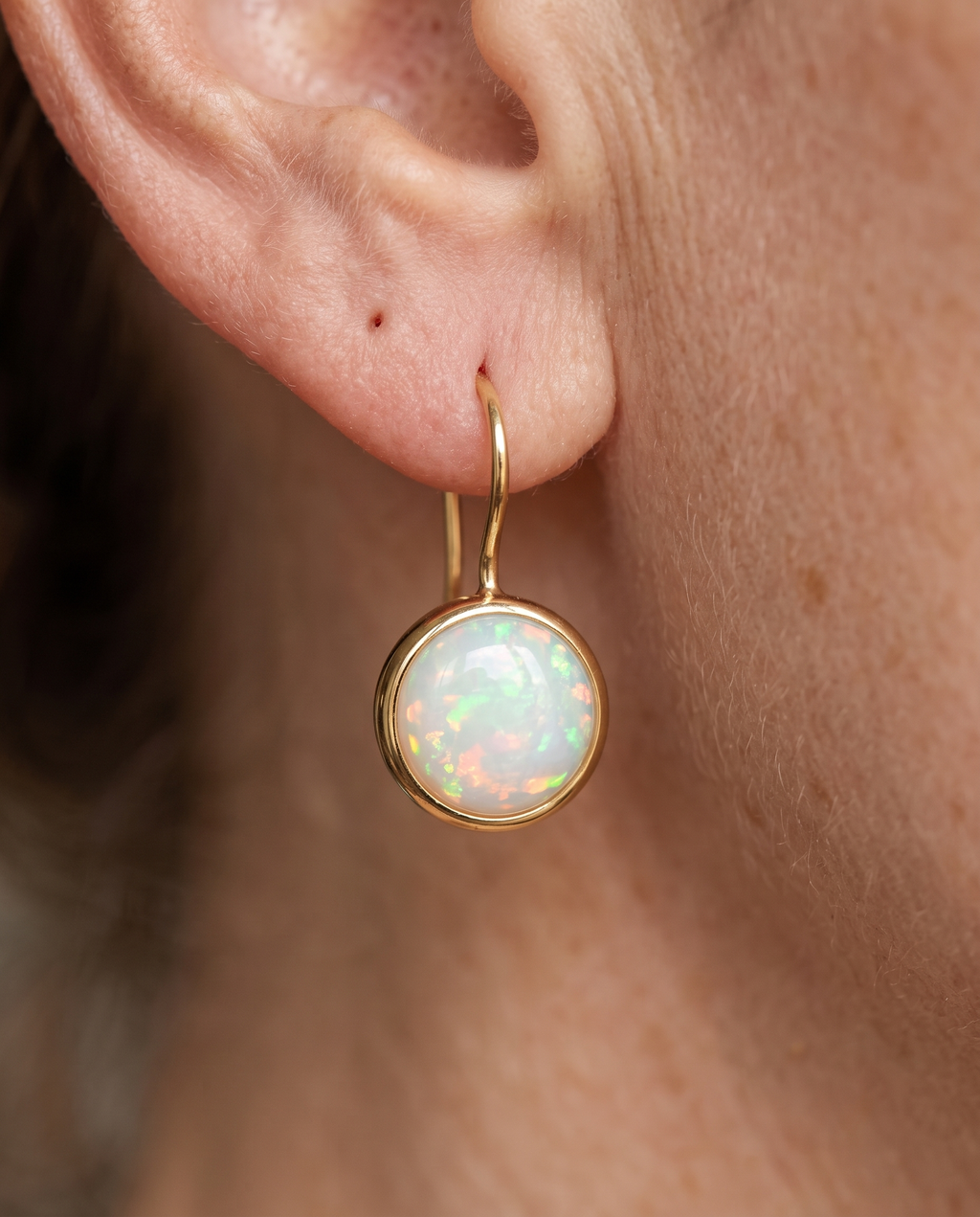 Golden Fire Opal Halo Drop Earrings worn on a model