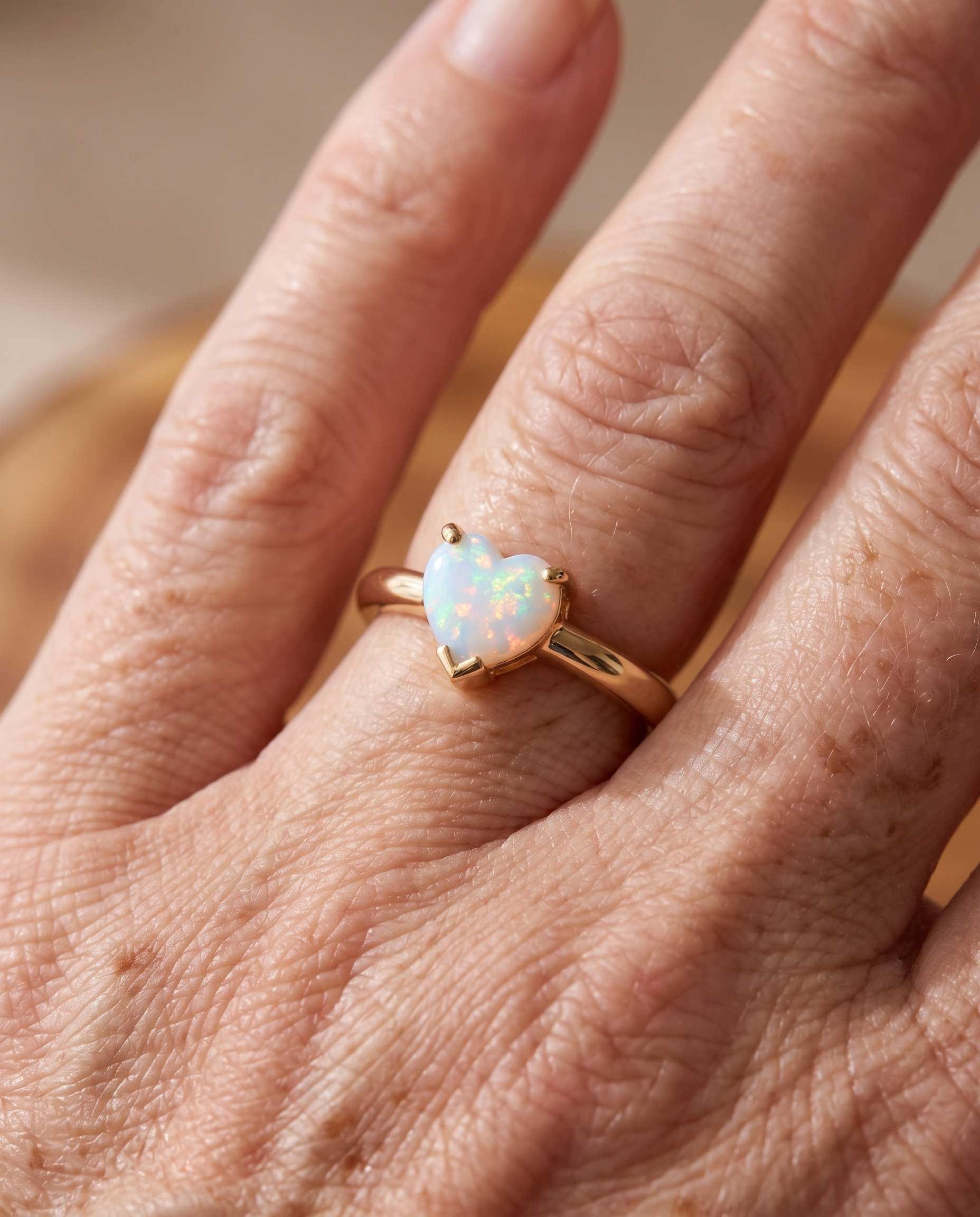 White Opal Heart Gold Ring worn on a model
