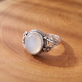 White Opal Leaf and Blossom Silver Ring on a tree-trunk slab