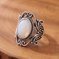 White Opal Scrollwork Silver Ring on a tree-trunk slab
